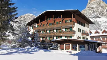 A view of the hotel's snowy exterior, with views of the surrounding vast mountains and trees.