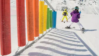Shots of a kids park in Hochgurgl, with young children swerving on their skis down a colourful slope.