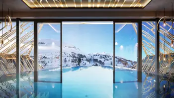 A shot from the Hotel's rooftop pool, showing bright blue skies and snowy mountains in the distance.